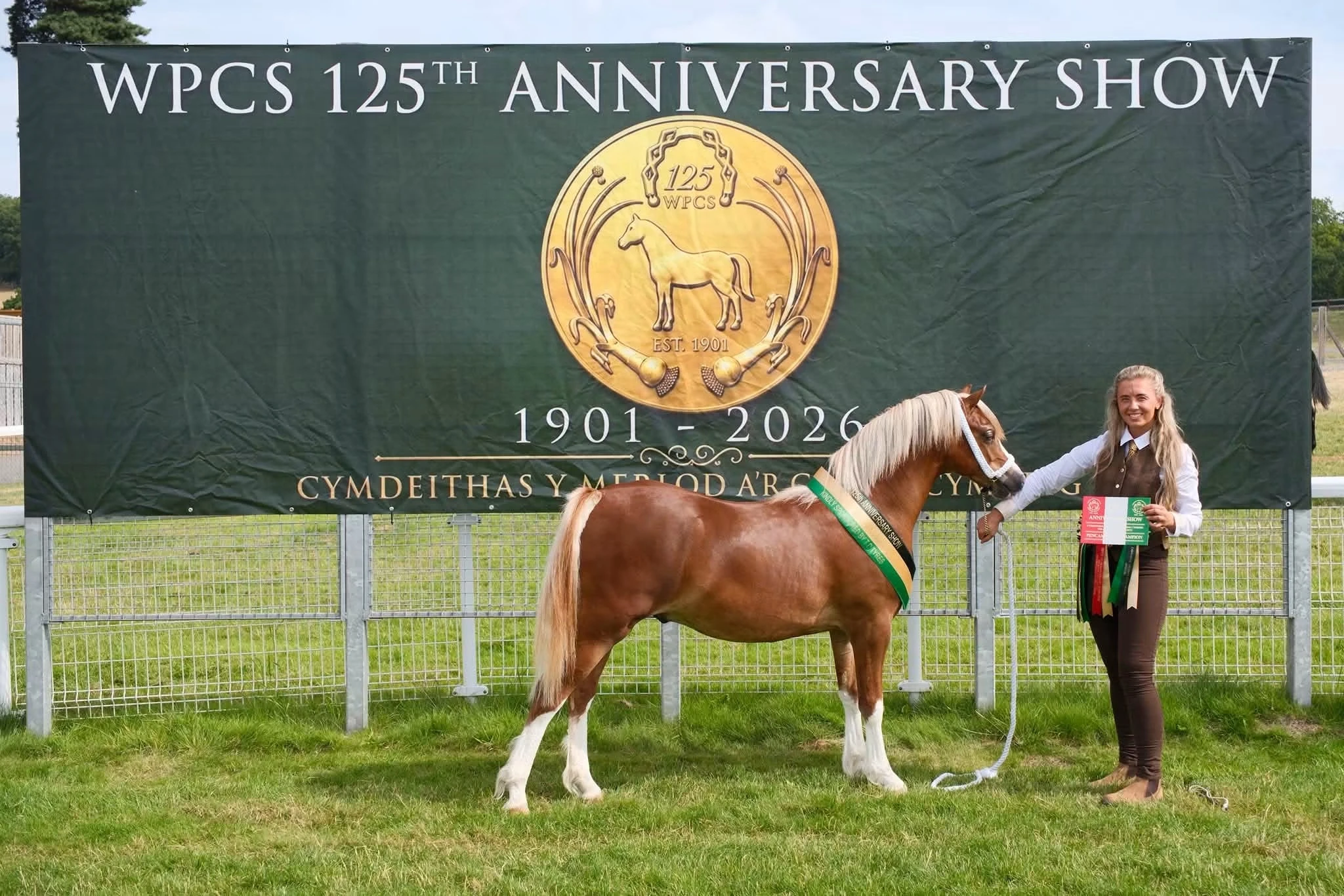 Albert and his handler in front of the WPCS 125th Anniversary Show banner